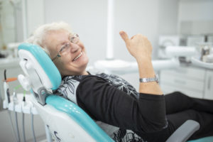 smiling elderly woman in dentist chair